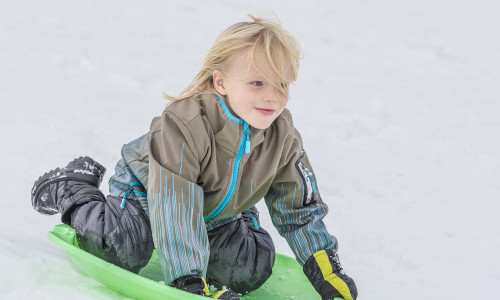 boy playing on toboggan in snow 2022 03 08 00 26 09 utc
